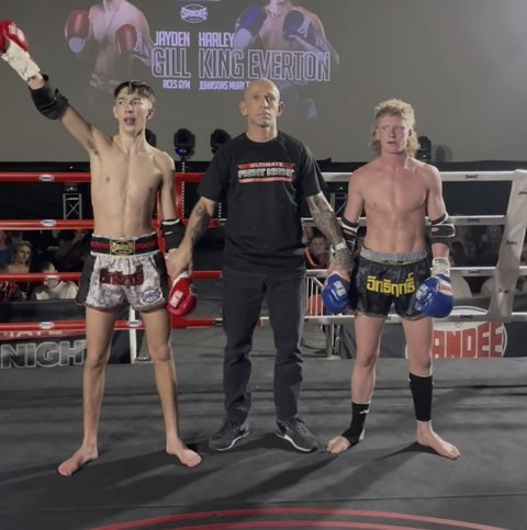 The referee raising Jayden Gill's hand after his win over Harley King Everton